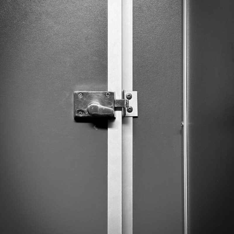 Close-up of a locked metal door with industrial design, emphasizing privacy.
